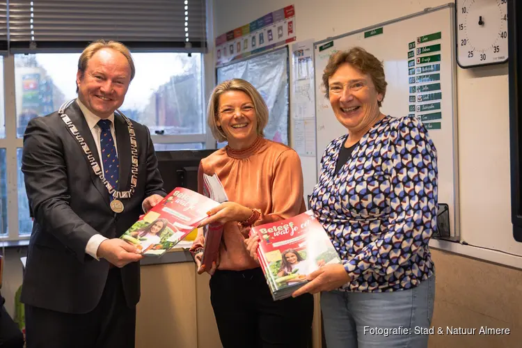 Burgemeester van Almere krijgt eerste kidsmagazine over voedselproductie overhandigd op basisschool het Spectrum